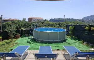 a swimming pool with two chairs and a hot tub at Casa Vacanze Mareluna in Agerola