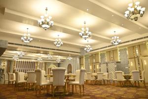 a conference room with tables and chairs and chandeliers at Club Central in Bolpur