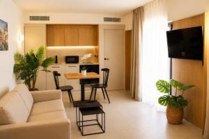 a living room with a couch and a table at Mallorca Suites Playa De Palma in Palma de Mallorca