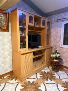 a large entertainment center with a television in a room at Buriram Cozy Home in Buriram
