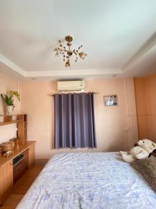 a bedroom with a large bed and a window at Buriram Cozy Home in Buriram