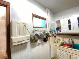 a kitchen with a sink and a bunch of pots and pans at Buriram Cozy Home in Buriram +14 photos