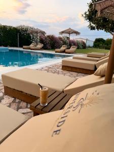 a pool with tables and chairs and a drink at Riverside Apartments in Ulcinj
