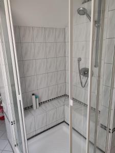 a shower in a bathroom with white tile at Traumhafte Lage am Kurpark in Bad Nauheim +12 photos