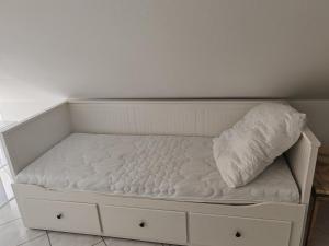 a white bed with a pillow on top of it at Traumhafte Lage am Kurpark in Bad Nauheim