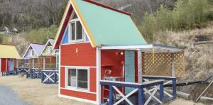 a small house with a colorful roof at パワースポットキャンプ場 in Shimoda