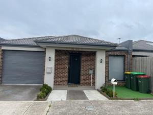 a brick house with two garage doors and a driveway at stay live love in Epping
