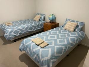 two beds sitting next to each other in a bedroom at stay live love in Epping