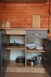 ein Holzschrank mit Töpfen und Pfannen in einer Küche in der Unterkunft Arpa Nest in Areni
