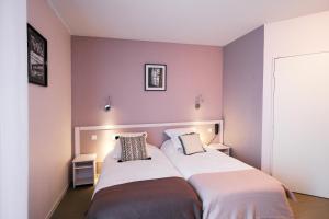 two beds in a room with purple walls at Domaine de Pousiniès in Saint-Étienne-de-Tulmont +12 photos