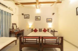 a bedroom with a bed and a desk in a room at Dumas Guest House in Pondicherry +29 photos
