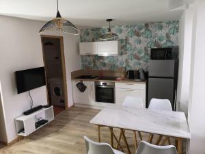 a kitchen with a table and chairs in a room at L'instant Doubs in Baume-les-Dames