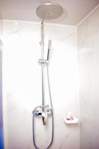 a shower with a blue hose in a bathroom at Saphir hotel in Kinshasa