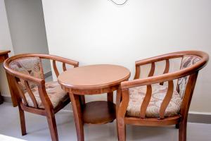 two wooden chairs and a table and a table and chairs at Saphir hotel in Kinshasa