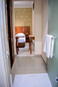 a bathroom with a bedroom with a bed and a table at Saphir hotel in Kinshasa