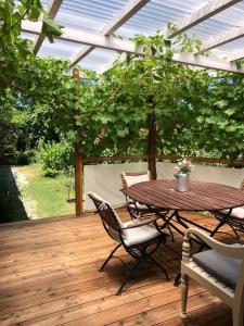 a patio with a table and chairs on a wooden deck at Tiny House zum See in Uhldingen-Mühlhofen +15 photos
