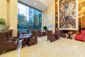 a lobby with tables and chairs and a large window at Shanghai Metropark Jichen Hotel in Shanghai +77 photos