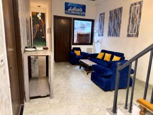 a living room with blue couches and yellow pillows at Jasmin A Luxury Stay-900m Walk To The Taj Mahal,Free Parking in Agra