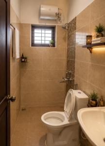a bathroom with a toilet and a sink at Vox Valavan in Mayiladuthurai