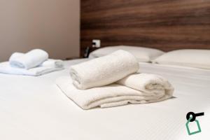 two towels are stacked on top of a bed at Hotiday Verona Fiera in Verona