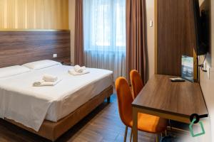 a bedroom with a bed and a desk and a table at Hotiday Verona Fiera in Verona