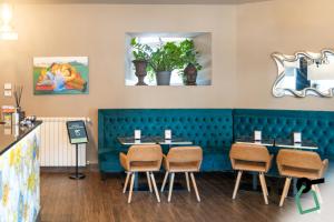 a dining room with blue booths and chairs at Hotiday Verona Fiera in Verona