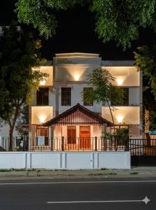 a large white building with a sign in front of it at Vox Valavan in Kuttālam