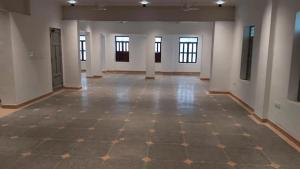 an empty room with a checkered floor in a building at Vox Valavan in Kuttālam