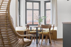 a dining room with a table and chairs and a window at Apartmány s výhledem na Plešivec by Mountain ways in Abertamy +35 photos