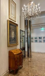 ein Zimmer mit einem Kronleuchter und einer Truhe in einem Museum in der Unterkunft Hotel Ambassador in Wien