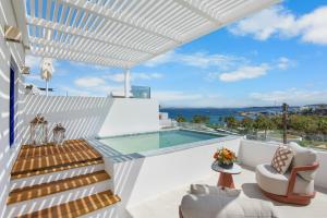 a white house with a swimming pool and stairs at Alexandros Apartments in Naousa