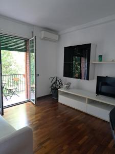 ein Wohnzimmer mit einem weißen Sofa und einem Fernseher in der Unterkunft Agrippa 24 in Mailand