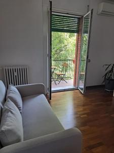 ein Wohnzimmer mit Sofa und Glasschiebetür in der Unterkunft Agrippa 24 in Mailand