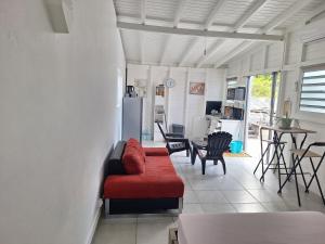 a living room with a red couch and a kitchen at Terrasson GOLD2 in Les Abymes