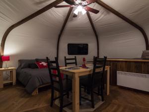 Habitación con mesa, cama y ventilador de techo. en Yourtes - Chalets Lanaudière, en Rawdon