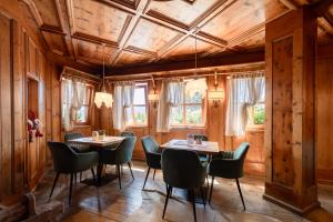 a dining room with wooden walls and tables and chairs at Park Hotel Bellacosta in Cavalese