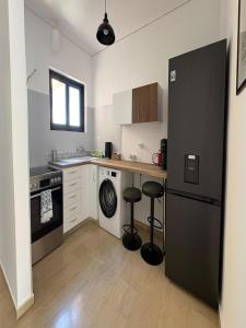 a kitchen with a black refrigerator and two stools at Oli' Studio in Oropos
