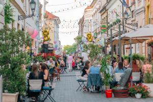 a crowd of people sitting in chairs on a city street at Malasits Apartman in Győr