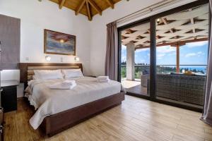 a bedroom with a large bed and a large window at Goudis Luxury Villas Lefkada Sea View & Private Pools in Tsoukalades +224 photos