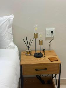 a nightstand with two lamps on it next to a bed at Cambridge Boutique Stay in Chiselhurst