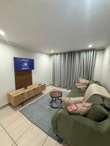 a living room with a couch and a flat screen tv at Cambridge Boutique Stay in Chiselhurst