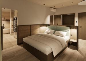 a bedroom with a large bed and a bathroom at Terra Saar, Weinresort & Spa in Saarburg
