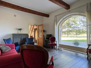 a living room with a red couch and a large window at Appartement Overcinge in Havelte
