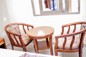 a table and two chairs and a table and a mirror at Saphir hotel in Kinshasa +47 photos