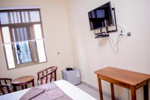 a room with a table and a tv on the wall at Saphir hotel in Kinshasa