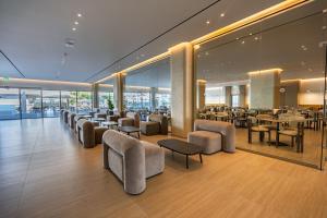 a restaurant with tables and chairs in a building at Sun Palace Protaras Waterpark Resort in Protaras
