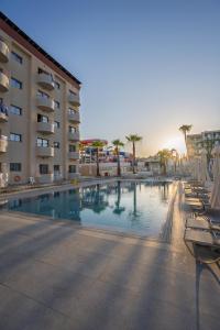 a large swimming pool next to a hotel at Sun Palace Protaras Waterpark Resort in Protaras