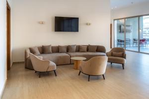a living room with a couch and a table and chairs at Sun Palace Protaras Waterpark Resort in Protaras