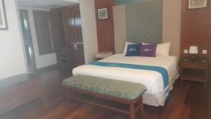 a bedroom with a bed and a bench in it at GLX Private Pool Villa in Port Dickson