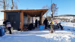 a group of people standing outside of a building in the snow at Apartmán vila Vítkovice in Vítkovice +9 photos